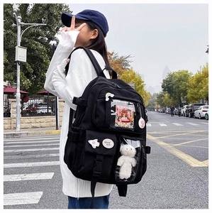 Detail view of black canvas backpack with transparent PVC layer and lucky badges