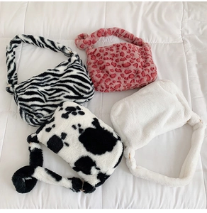 Detail showing four plush faux fur shoulder bags in zebra, cow, pink leopard and white