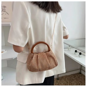 Detail of crystal pleated handbag with round wooden handle and gold chain strap
