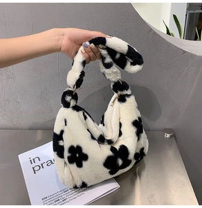 Detailansicht der flauschigen Schultertasche mit schwarz-weißem Blumenmuster und Reißverschluss
