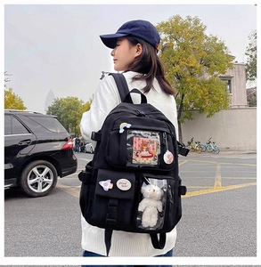 Detail of black school backpack with transparent window and cute decorative badges