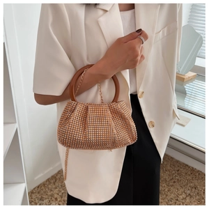 Detail showing shiny champagne gold rhinestone mesh with a round brown handle and gold chain