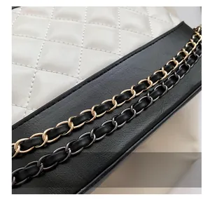 Detail of dual-tone metal chain straps on white quilted leather shoulder bag