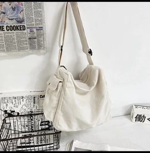 Detailansicht der cremefarbenen Segeltuchtasche mit seitlicher Klappentasche und Trageriemen