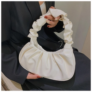 Close-up of a white pleated cloud bag with soft PU leather texture and ruched handle