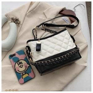 Detail shot of a quilted leather hobo bag with contrast bicolor design and chain straps