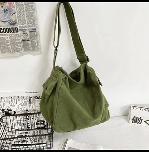 Detailansicht der grünen Canvas-Umhängetasche mit verstellbarem Gurt und Klapptasche