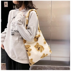 Detailed close-up of soft beige plush tote bag with cute brown bear patterns
