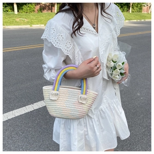 Close-up of handmade rainbow cotton crochet handbag with soft pastel colors and tassel detail