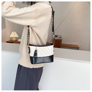 Close-up of diamond quilted stitching and metallic chain strap on women's shoulder bag