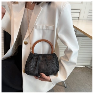 Detail of black rhinestone hand bag featuring round wooden handle and gold chain strap