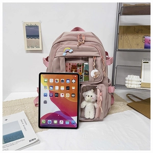 Detail view of pink multi-pocket canvas backpack with cute doll and large storage capacity