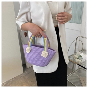 Detail of lilac woven handmade cotton bag with blue-yellow handle and white fringe