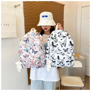 Detailed close-up of butterfly print backpacks with front pockets and plush bear charms