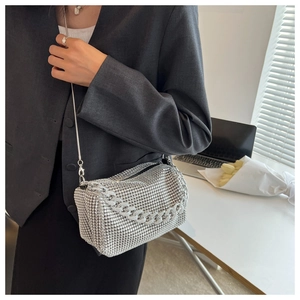 Detailed view of silver rhinestone crossbody bag with metal chain straps and zip closure