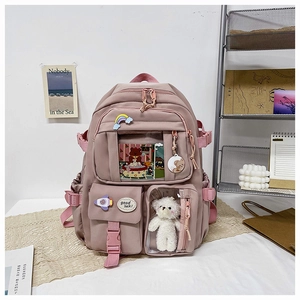 Close-up of pink school backpack with transparent pockets and cute bear plush charm