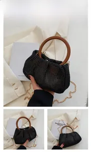 Detail of black rhinestone woven bag with vintage wood handle and gold chain strap