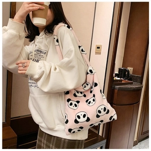 Close-up detail of soft pink plush tote bag featuring cute panda patterns and furry texture