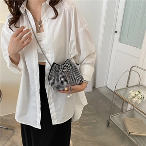 Chic black bucket bag with silver rhinestones and pearl drawstring on a model