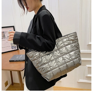 Close-up of a silver quilted puffer tote bag showing the metallic texture and large capacity