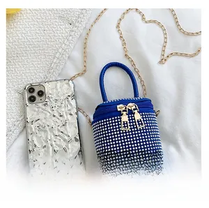 Deep blue micro rhinestone cylinder bag compared with a mobile phone for size detail