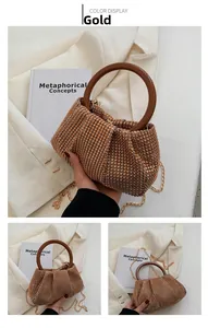 Close-up of sparkling gold rhinestone woven bag with wooden handle and metal chain strap