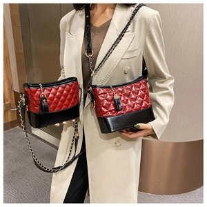 Detail view of two-tone quilted hobo bag with red diamond stitching and black smooth base