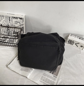 Macro shot of durable black canvas tote bag base showing thick cotton fabric texture