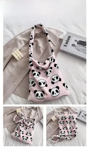 Detail view of the soft pink plush tote bag with black and white panda patterns