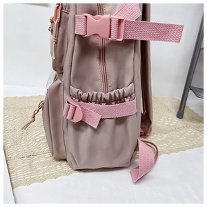 Detail view of the lotus pink nylon backpack featuring elastic side pockets and buckles