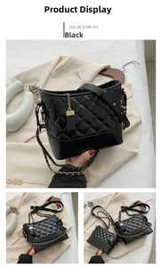 Detail view of black quilted leather shoulder bag with gold chain strap and square pendant