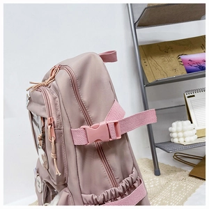 Detail of pink-purple nylon backpack showing multi-layer zippers and side pockets