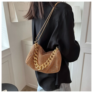 Detail of luxury rhinestone shoulder bag with dual gold chain straps and sparkling finish