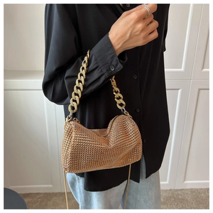 Detail shot of golden hobo bag with sparkling rhinestones and thick metal chain strap