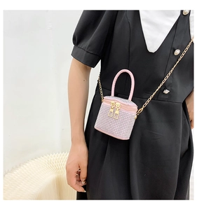 Detail of pink rhinestone bucket bag with double zipper and gold chain crossbody strap