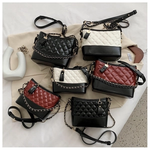 Detail of quilted leather bags with metal chain straps and tassel pendants in three colors