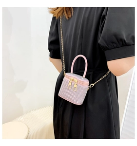 Detailed close-up of a pink rhinestone cylinder mini bag with gold chain strap on a model