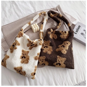 Close-up of fluffy sherpa tote bags with cute bear pattern in beige and brown colors