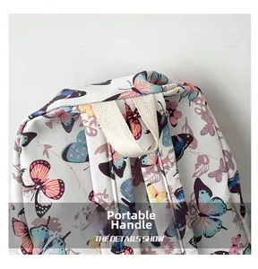 Detail of the reinforced portable top handle on a white backpack with butterfly pattern