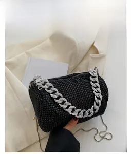 Detail of black cylinder handbag with sparkling rhinestones and silver chain strap