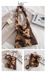 Detail of dark brown plush tote bag featuring yellow cartoon bear jacquard patterns