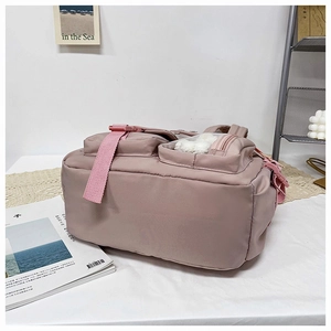 Detailed view of pink nylon backpack base with reinforced straps and side mesh window