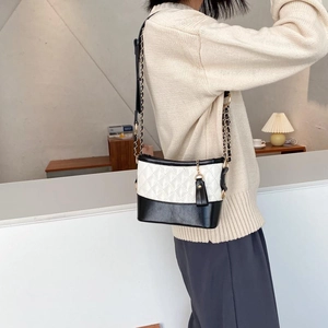 Quilted black and white crossbody bag with gold chain strap and leather tassel detail