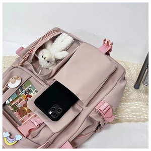 Detail view of pink Japanese style backpack with cute plush bear and pocket layers