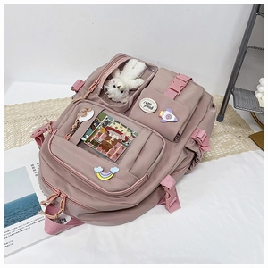 Detail view of pink nylon school backpack with transparent pockets and decorative badges