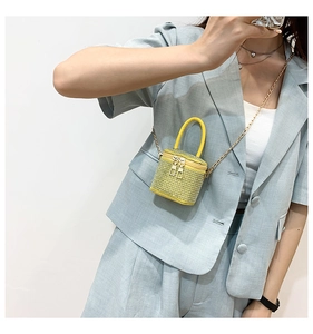 Mini yellow bucket bag with sparkling rhinestones and golden chain strap on a model