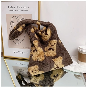 Detailed close-up of brown plush tote bag with cute bear pattern and soft fleece texture
