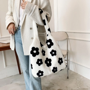 Model wearing a plush faux fur tote bag with black floral pattern on a white base