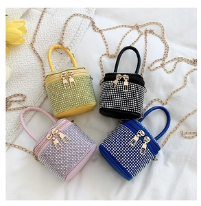 Close-up of four colorful mini bucket bags with rhinestones and gold chain straps