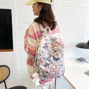 White Harajuku backpack with colorful butterfly print and cute plush bear keychain charm